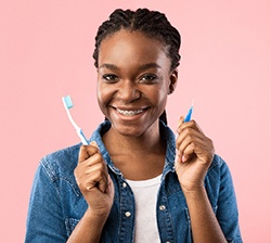 Smiling patient with braces holding toothbrush