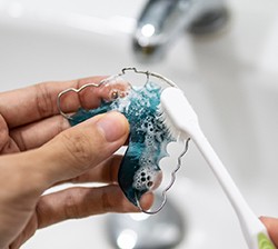 Patient cleaning retainer with toothbrush
